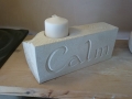 Pillar candle holder with flower leaves and calm carved into it. Portland limestone.